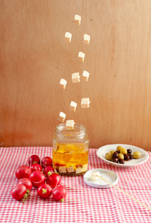 A vertical shot of feta cheese falling into glass jarの写真素材