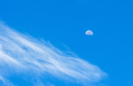 A beautiful view of the blue sky with clouds and the moonの写真素材