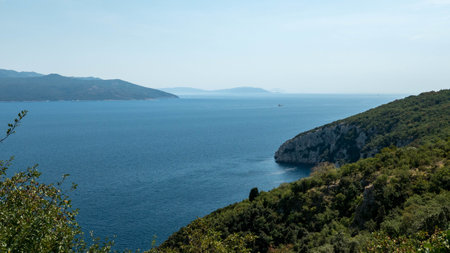 A landscape of the sea surrounded by cliffs covered in greenery under a blue skyの写真素材