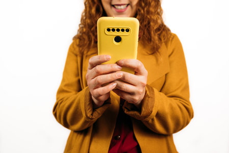 A closeup shot of a female holding her smartphone on an isolated backgroundの写真素材