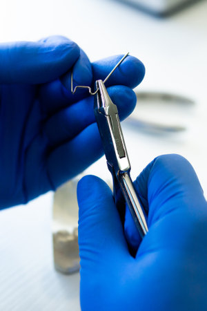 A verti shot of hands of a dental technician making new Prosthetics dental in laboratory