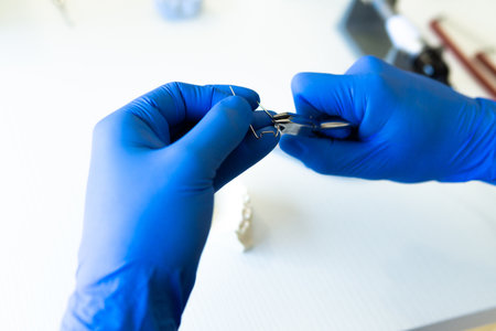 A closeup shot of hands of a dental technician making new Prosthetics dental in laboratoryの写真素材