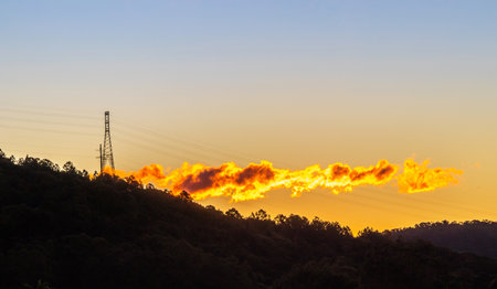 A beautiful shot of sunset over greenery-covered hillsの写真素材