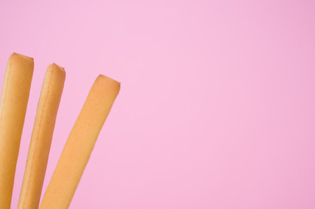 A closeup shot of three breadsticks isolated on pbackgroundの写真素材