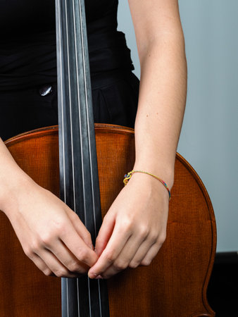 A vertical shot of a female holding the cello