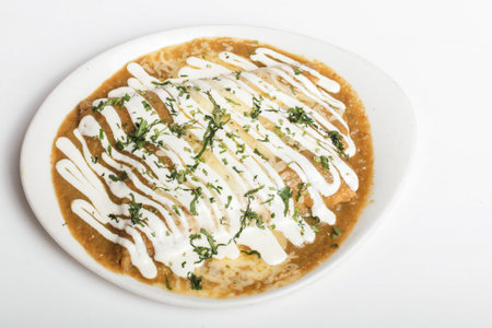 A closeup shot of deliciously prepared meat in sauce with herbs on top