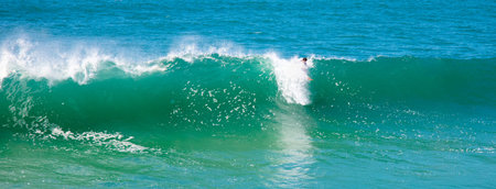 A surfer surfing in the large green waves