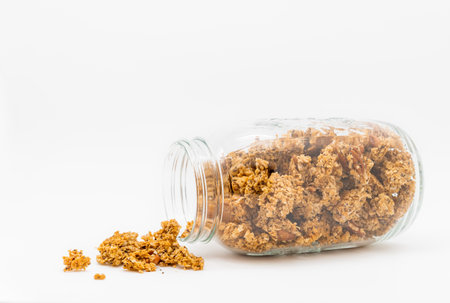 A closeup shot of a glass jar with granola made from oats and chia seeds isolated on white...