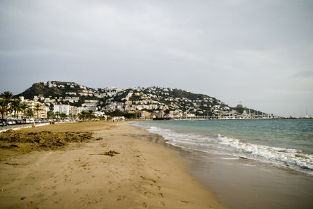 A scenic shot of a sandy beach in Roses, Spainの写真素材