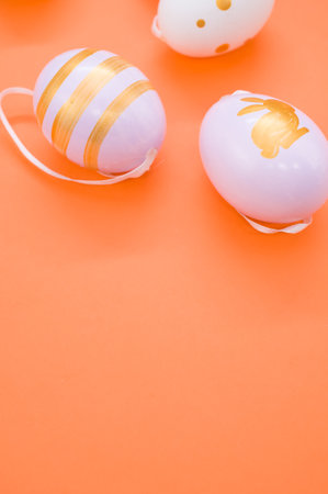 A closeup shot of decorative Easter eggs on an orange surface - copy space