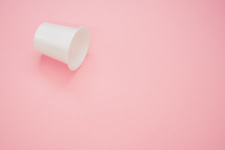 A disposable plastic cup on a pink backgroundの写真素材
