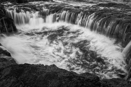A grayscale shot of a waterfall in Gran Canaria, Canary Islandsの写真素材