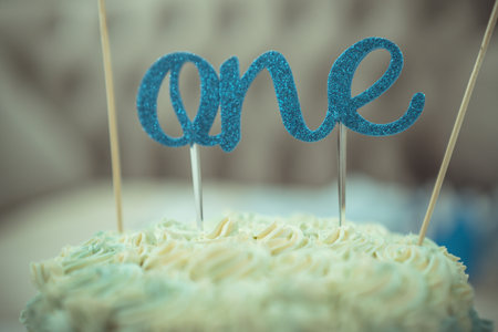 One year Birthday Cake on blue textの写真素材