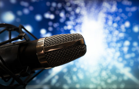 A wide-angle view of a microphone with a pedestal at a party atmosphere with colorful light backgroundの写真素材