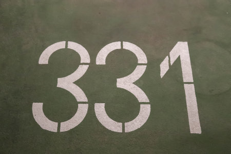 A high angle shot of numbers painted on the asphalt and cement on a roadの写真素材