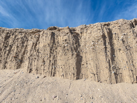 An edge of a sandy coast full of rocks under the clear blue skyの写真素材