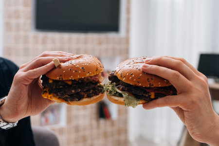 A closeup shot of people holding delicious hamburgers upの写真素材