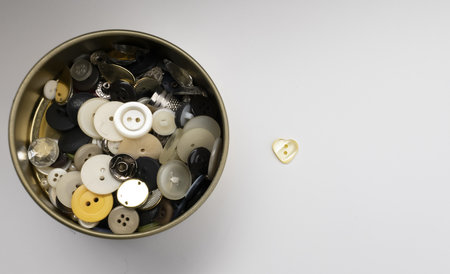 An overhead shot of a sewing box with buttons of various sizes and colorsの写真素材