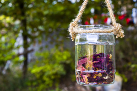 A glass jar with dry flower petalsの写真素材