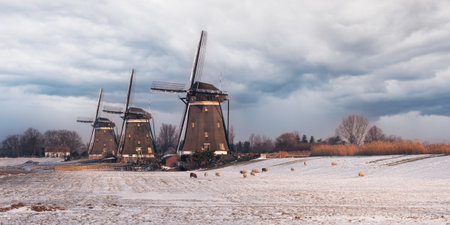 The three large windmills on a field under a bright skyの写真素材