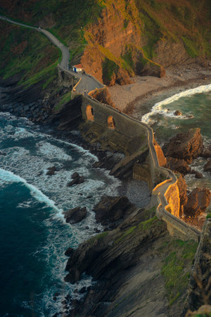 An old bridge through the water to an island San Juan de Gaztelugatxe in the Basque countryの写真素材