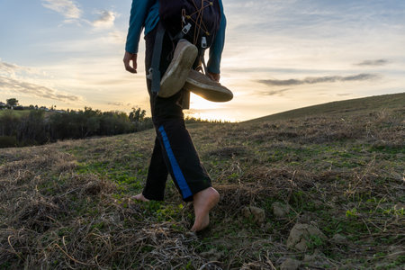 Stock photo of unrecognized man with backpack hiking in the forest. He is barefoot.の写真素材