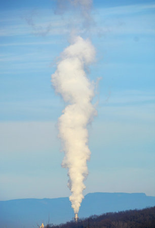 A vertical shot of industrial smoke on the sky backgroundの写真素材