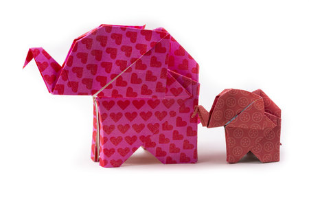 A closeup shot of patterned origami elephants of different sizes isolated on a white backgroundの写真素材