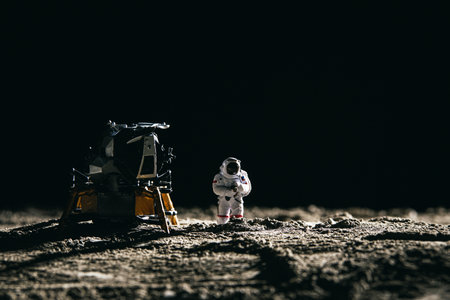 An astronaut miniature toy next to a spaceship on the moonの写真素材