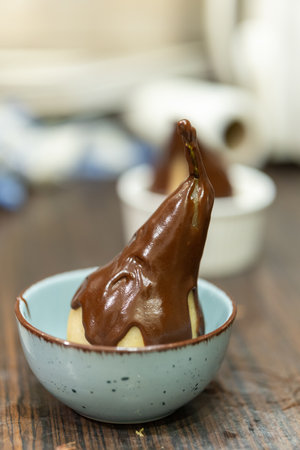 A vertical shot of chocolate glazed candy in a bowl on the tableの写真素材