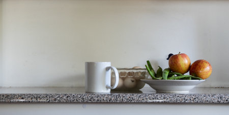 A closeup shot of apples, eggs and a mug on the table. Morning vibes