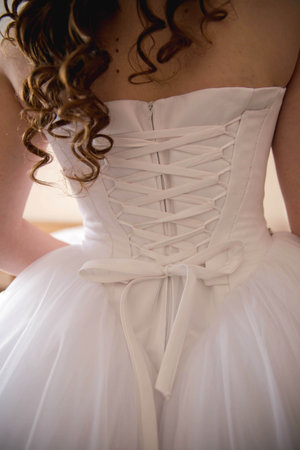 A vertical back view of a bride in a dress with a corset backの写真素材