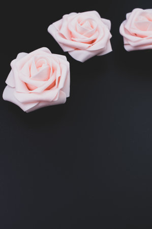 A vertical shot of pink decorative roses isolated on a black backgroundの写真素材