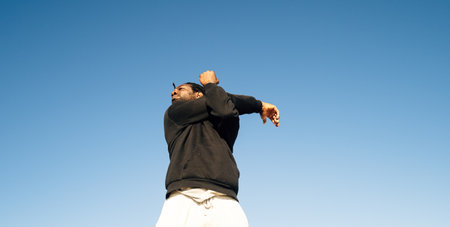 A young African-American male stretching on a beachの写真素材