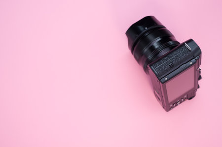 A closeup of a photo camera isolated on a pink backgroundの写真素材