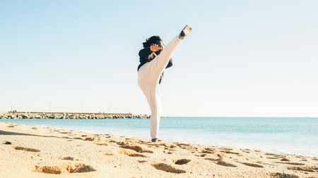 A young African-American male practicing kicks on a beachの写真素材