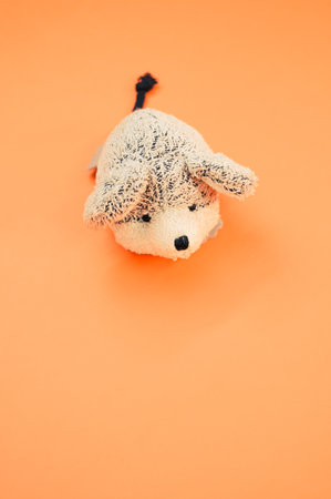 A vertical shot of a cute fluffy mouse toy on an orange surfaceの写真素材