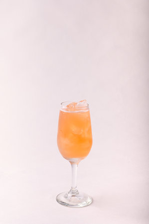 A glass of delicious Bellini cocktail isolated in the light backgroundの写真素材