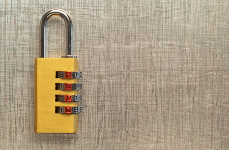A closeup shot of a combination padlock with a safety code on a golden background - copy spaceの写真素材