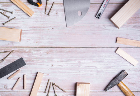 A top view of pieces of wood and tools for construction and repair on a wooden table with copy spaceの写真素材