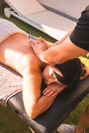 A vertical shot of a masseur doing massage to an attractive Hispanic femaleの写真素材