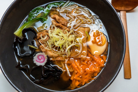 A bowl of pork belly Japanese ramen with noodles, fresh vegetables and boiled eggの写真素材