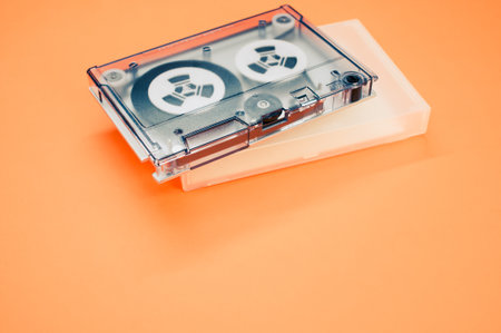 A cassette tape with a case on an orange backgroundの写真素材