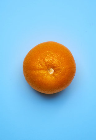 A vertical shot of fresh orange on a blue background