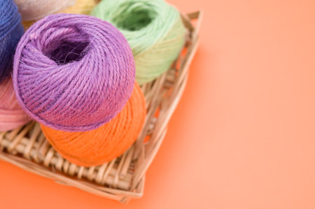 A set of colorful yarns on an orange background with space for textの写真素材