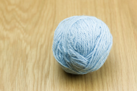 A blue yarn ball on the wooden surface
