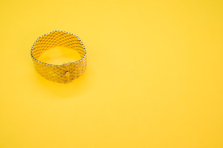 A vintage golden bracelet isolated on a yellow backgroundの写真素材