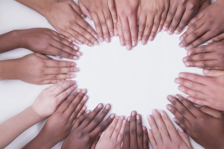 Asian African European hands with arms on a white backdrop positioned in a heart shapeの写真素材