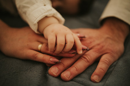 A closeup shot of a baby holding mother's and father's hands
