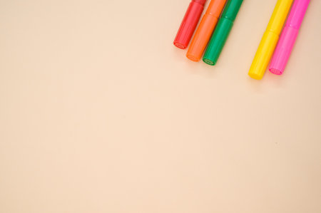A closeup shot of colorful markers isolated on a pink background with space for textの写真素材
